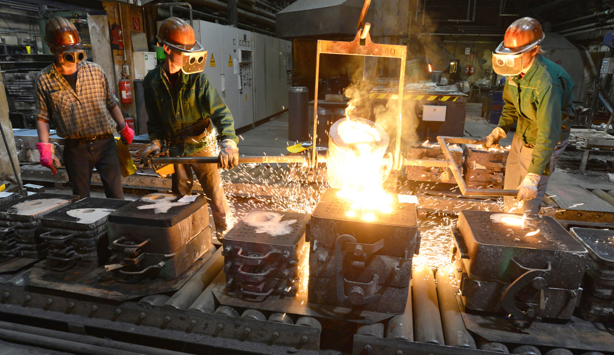 Workers in a foundry casting a metal workpiece